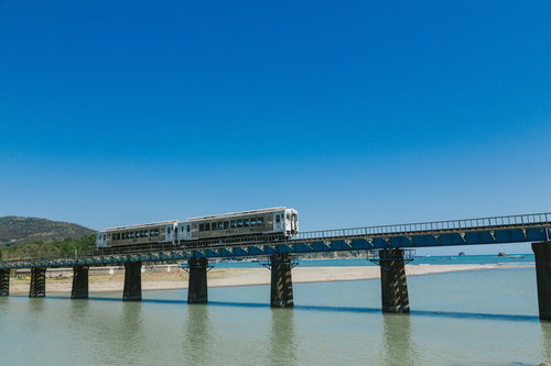 青空に映える海幸山幸観光列車が橋を渡る宮崎県日南市