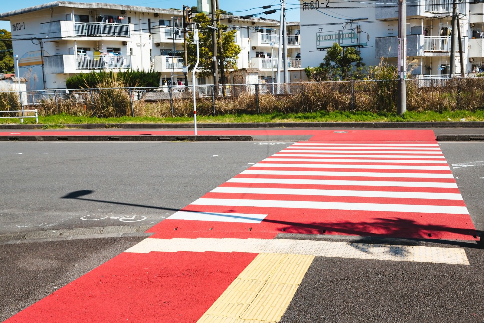 住宅地に設置された紅白ストライプの横断歩道と誘導ブロック