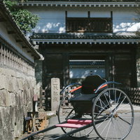 飫肥城の大手門前に停車する黒い人力車と城下町の風景の写真