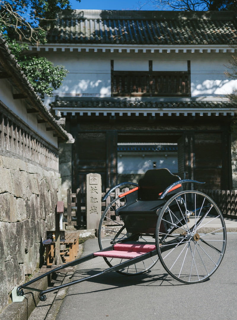 飫肥城の石垣造りの大手門前に停車する黒い人力車