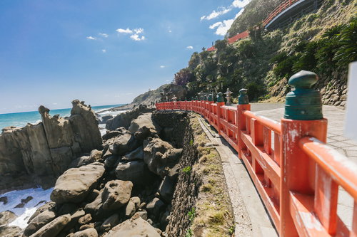 鵜戸神宮の朱色の玉垣と海岸の絶壁、青空と海