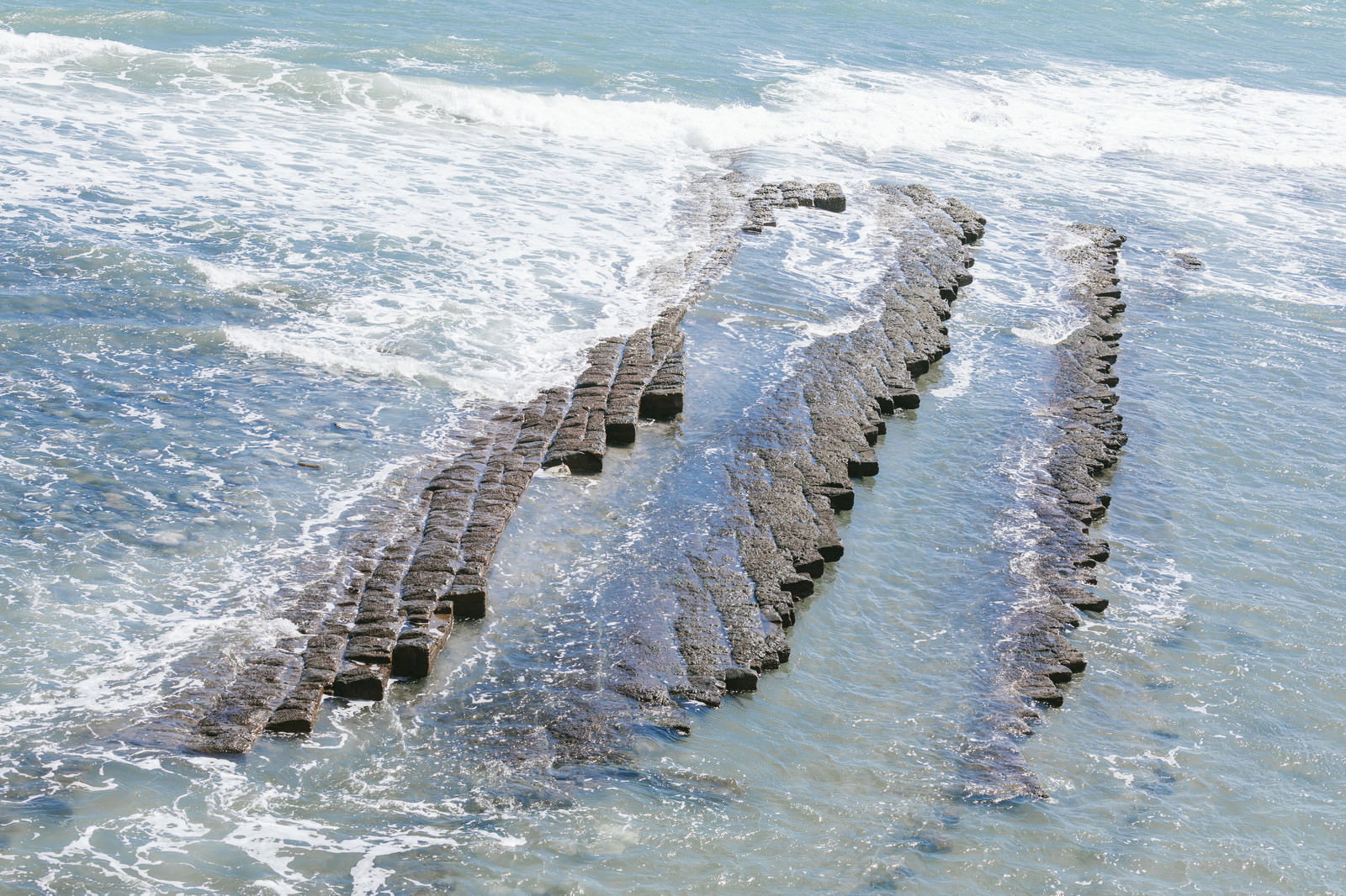海岸に広がる鬼の洗濯岩の波状模様と打ち寄せる白い波