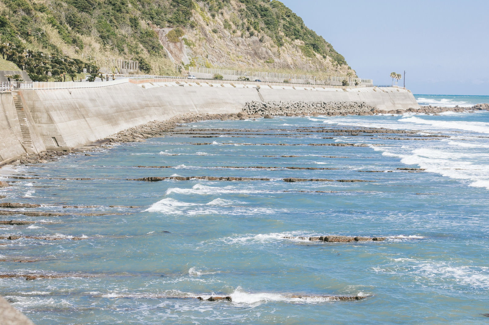 栄松ビーチの白い砂浜でオレンジ色のシーカヤックを準備する2人