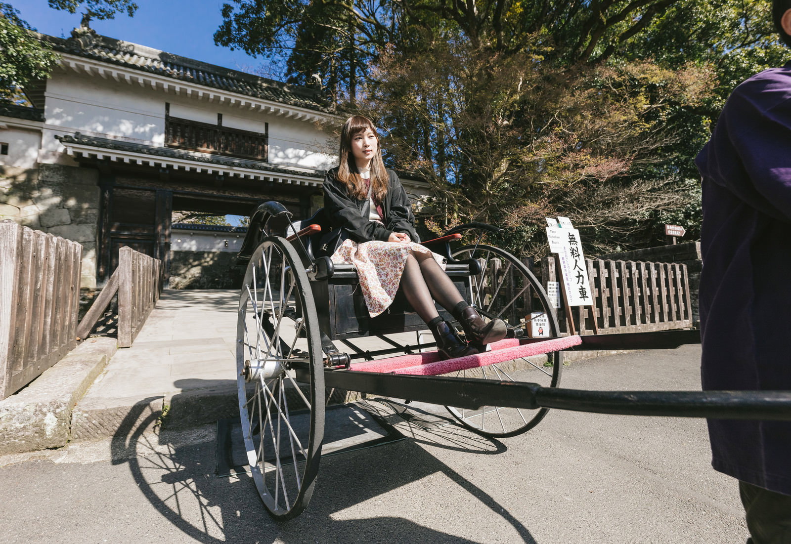 飫肥城大手門前で人力車に座る女性観光客