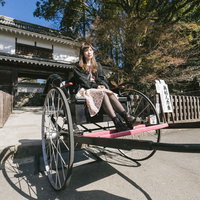 飫肥城の大手門前で人力車に乗る女性観光客の写真