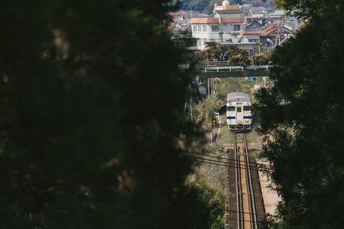 山の合間を走る日南線の列車 宮崎県の山間を走るローカル線