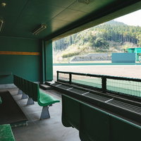 天福球場のベンチから見るグランドと観客席の写真