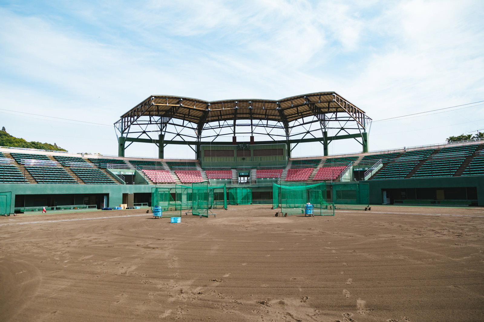 天福球場の内野グラウンドと緑色の観客席、奥に屋根付きスタンド
