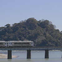 虚空蔵島をバックに海を走る観光列車「海幸山幸」の写真