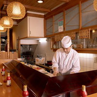 温かみのある木目調の寿司幸店内で調理する寿司職人の写真