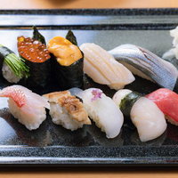 黒い皿に盛り付けた握り寿司の豪華な盛り合わせの写真