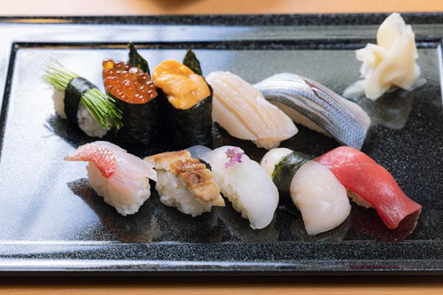 黒い皿に盛り付けた握り寿司の豪華な盛り合わせ
