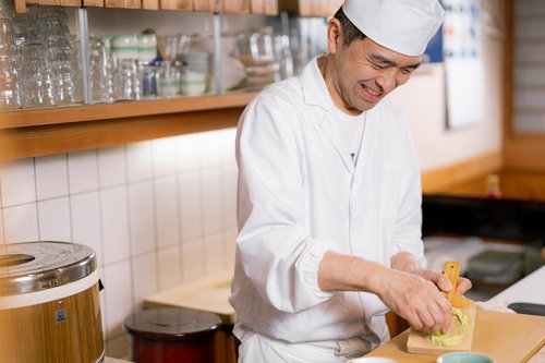 黒いまな板でわさびをおろす寿司職人の調理風景