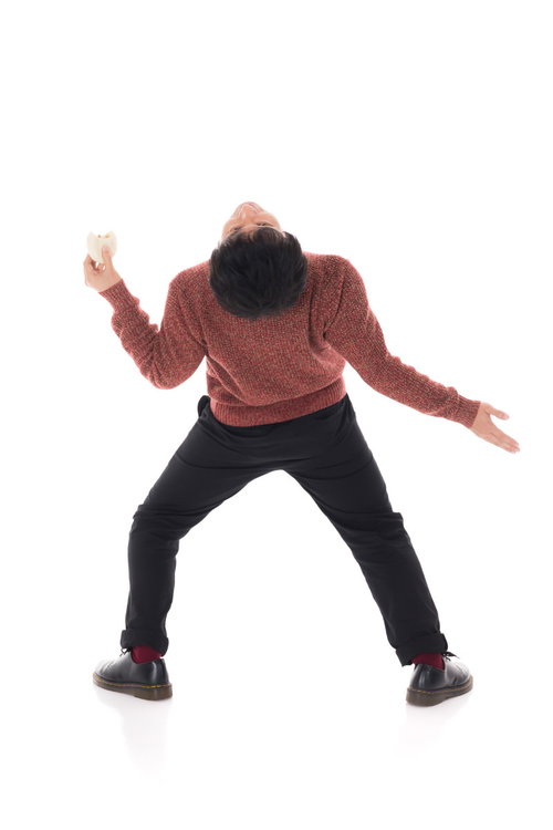 肉まんを食べながらイナバウアーをする男性