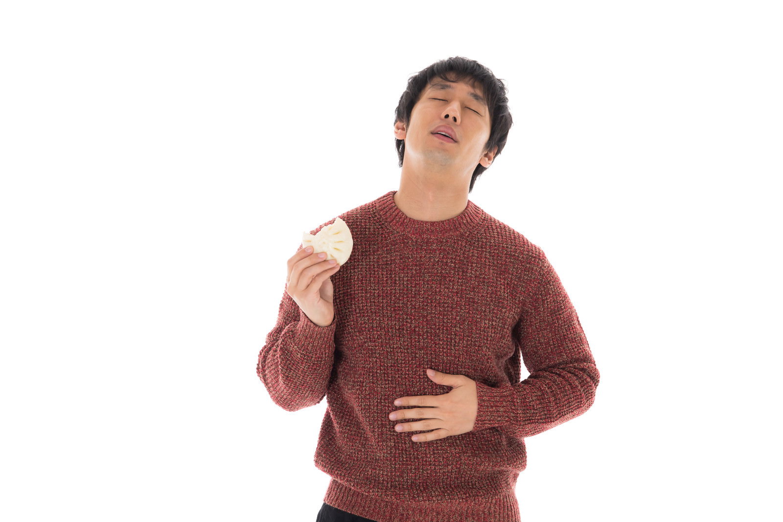 赤いセーターを着た男性がコンビニの肉まんを持って感動している様子［モデル：大川竜弥］
