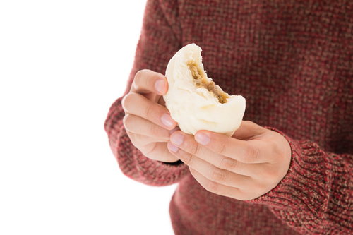 プレミアムな具材が詰まった肉まんを食べる男性