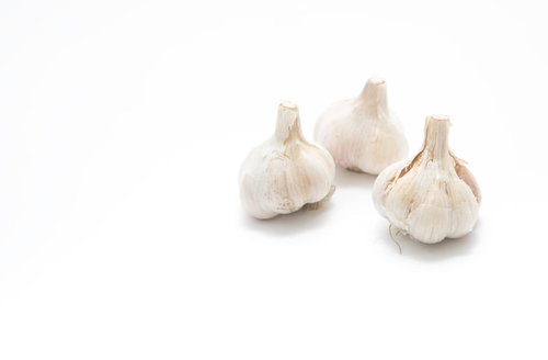 皮を剥く前の白いにんにく（3つ）の食材