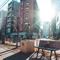 日暮里の街角に立つ響 Echo の銅像とベンチの写真