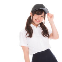 帽子をかぶって笑顔を見せる女子マネージャーの写真