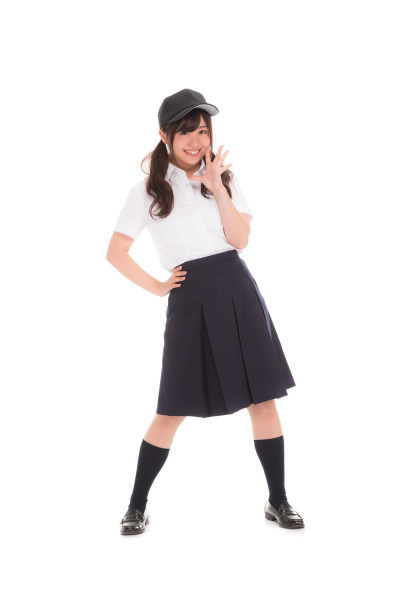 白いシャツと紺のスカートを着た女子高生が元気よく応援ポーズをとっている［モデル：河村友歌］