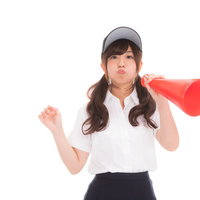 メガホンを持ち抗議のポーズをとる女子マネの写真