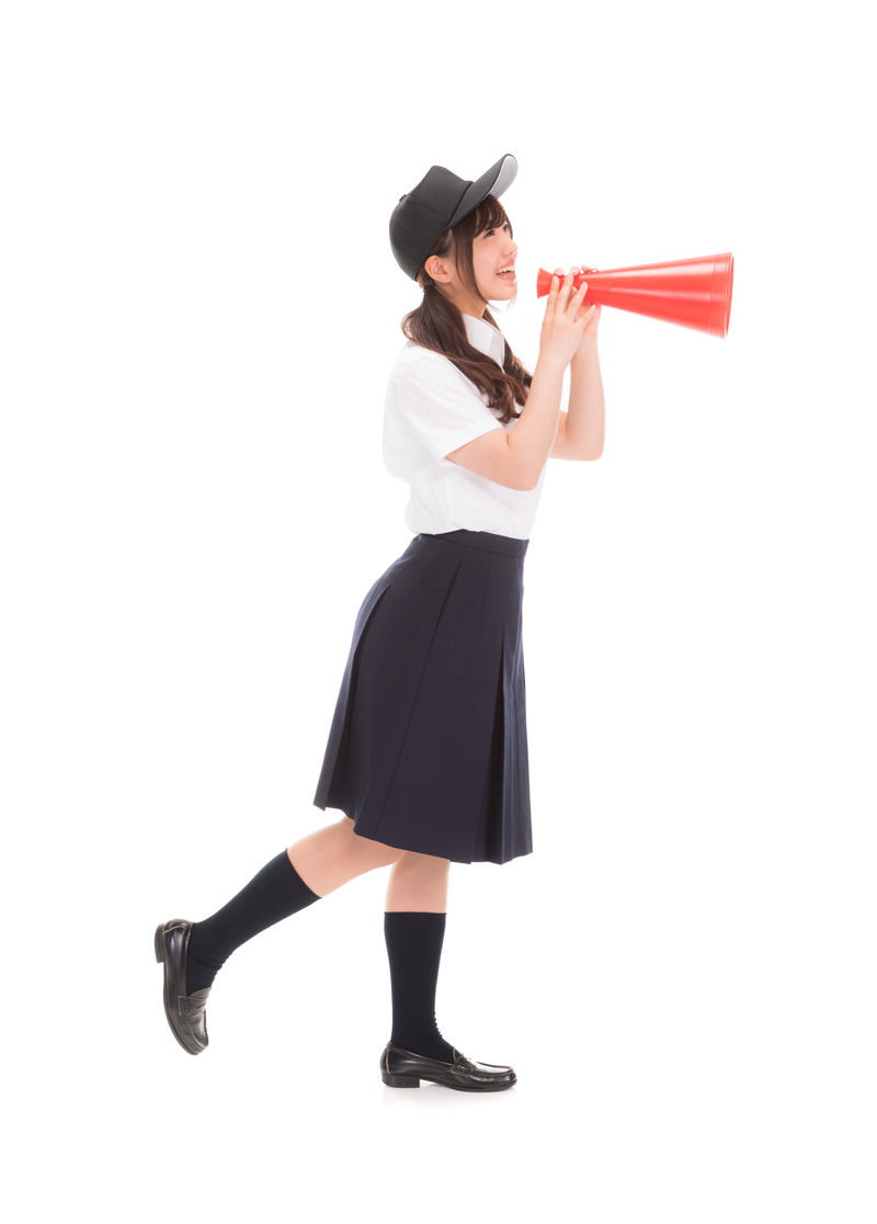 赤いメガホンで応援する制服姿の女子高生［モデル：河村友歌］