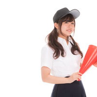 赤いメガホンを手にミスを追求する女子マネの写真