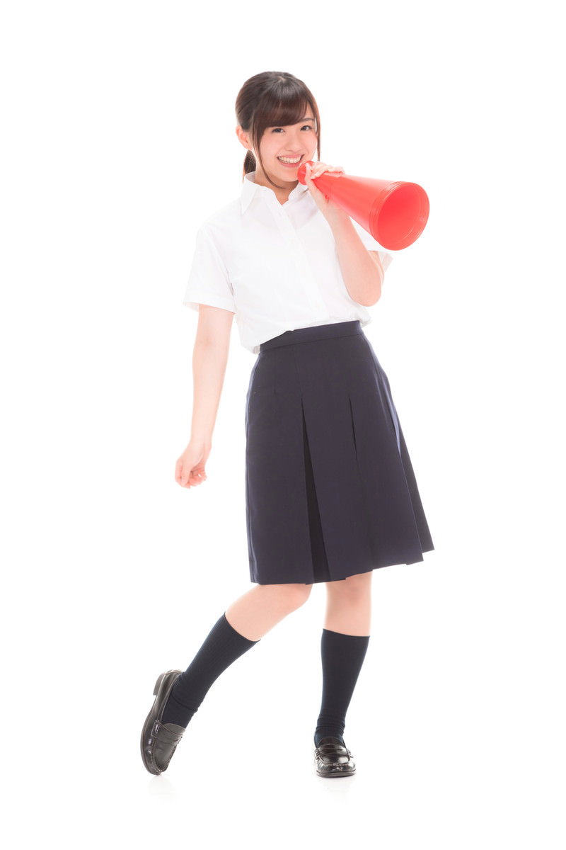 赤いメガホンを持ち応援する制服の女子高生［モデル：河村友歌］