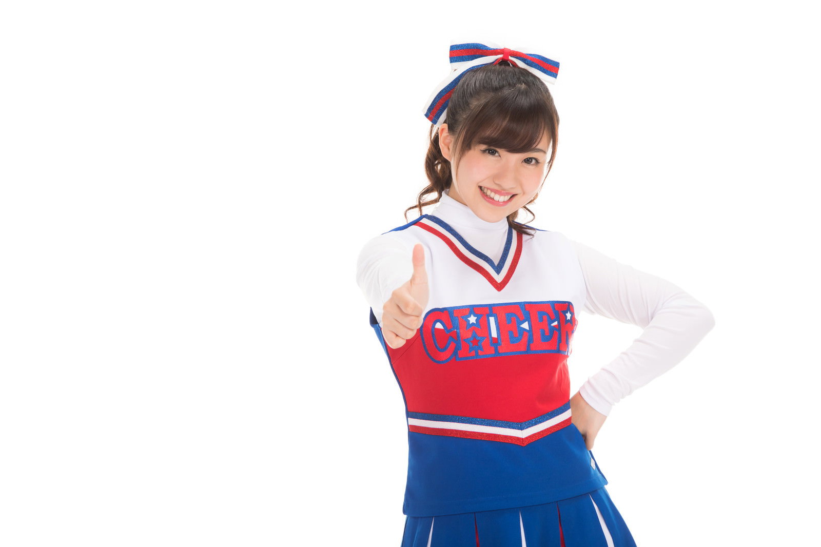 チアユニフォーム姿の女性が右手の親指を立ててアピールしながら笑顔で見つめている［モデル：河村友歌］