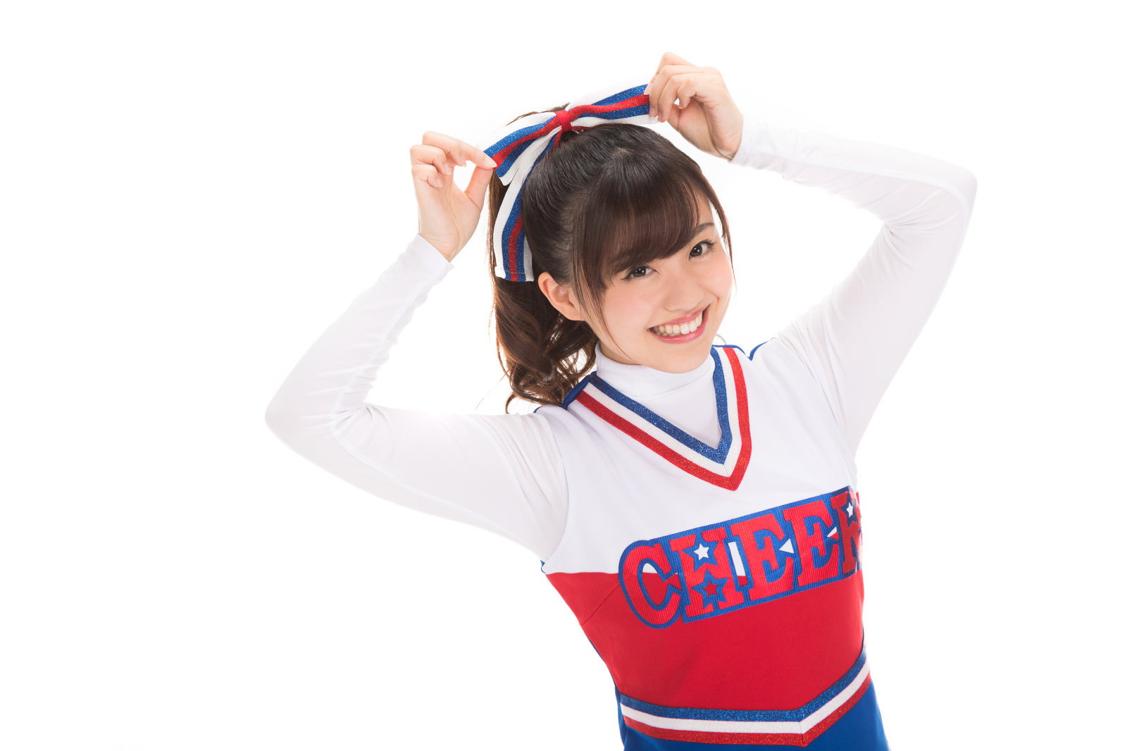 赤と白のチアユニフォームを着てポンポンを持つ女性［モデル：河村友歌］