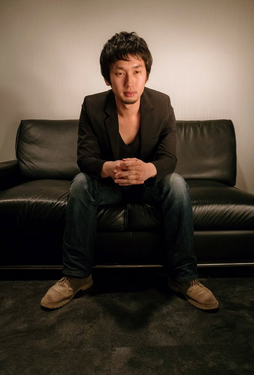 バーのソファーの上で指を組んでくつろぐ余裕のある男性