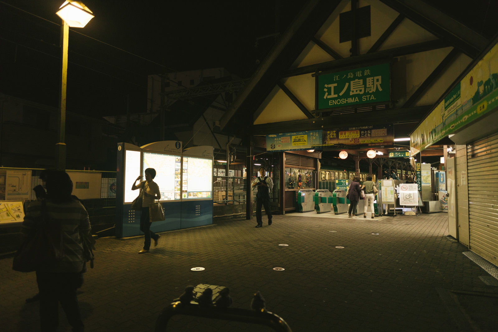 夜の江ノ島駅前と照明に照らされた駅舎
