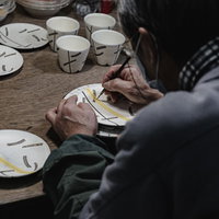 直方市の伝統工芸で陶器に絵付けする職人の後ろ姿の写真