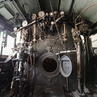 燃料である石炭を中央の火室が開いた状態の機関室内の写真