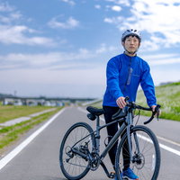 晴れた日にロードバイクで直方北九州自転車道を走り出そうとする男性の写真