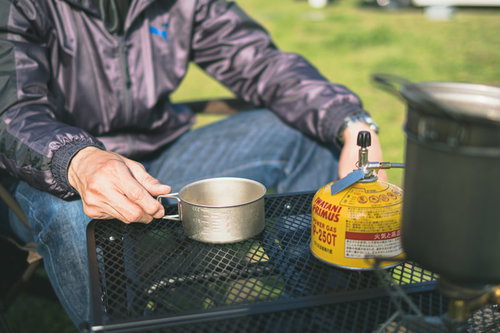 テーブルの上でお湯を沸かすソロキャンパーの手元