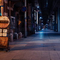 錆びた案内板と閉店した直方市の商店街アーケード夜景の写真