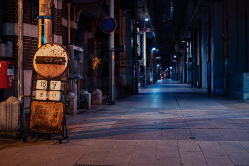 錆びた案内板と閉店した直方市の商店街アーケード夜景