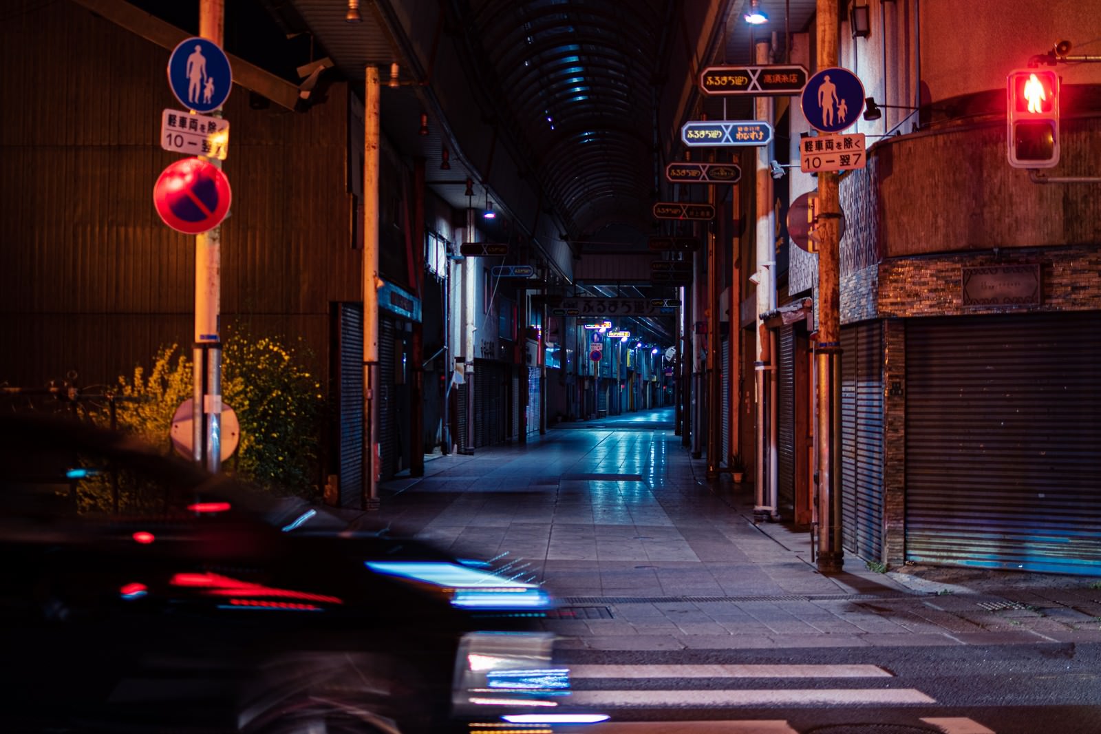 夜の商店街で街灯に照らされた横断歩道と静かな道路の風景