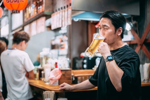 居酒屋でビールをうまそうにごくごく飲む男性