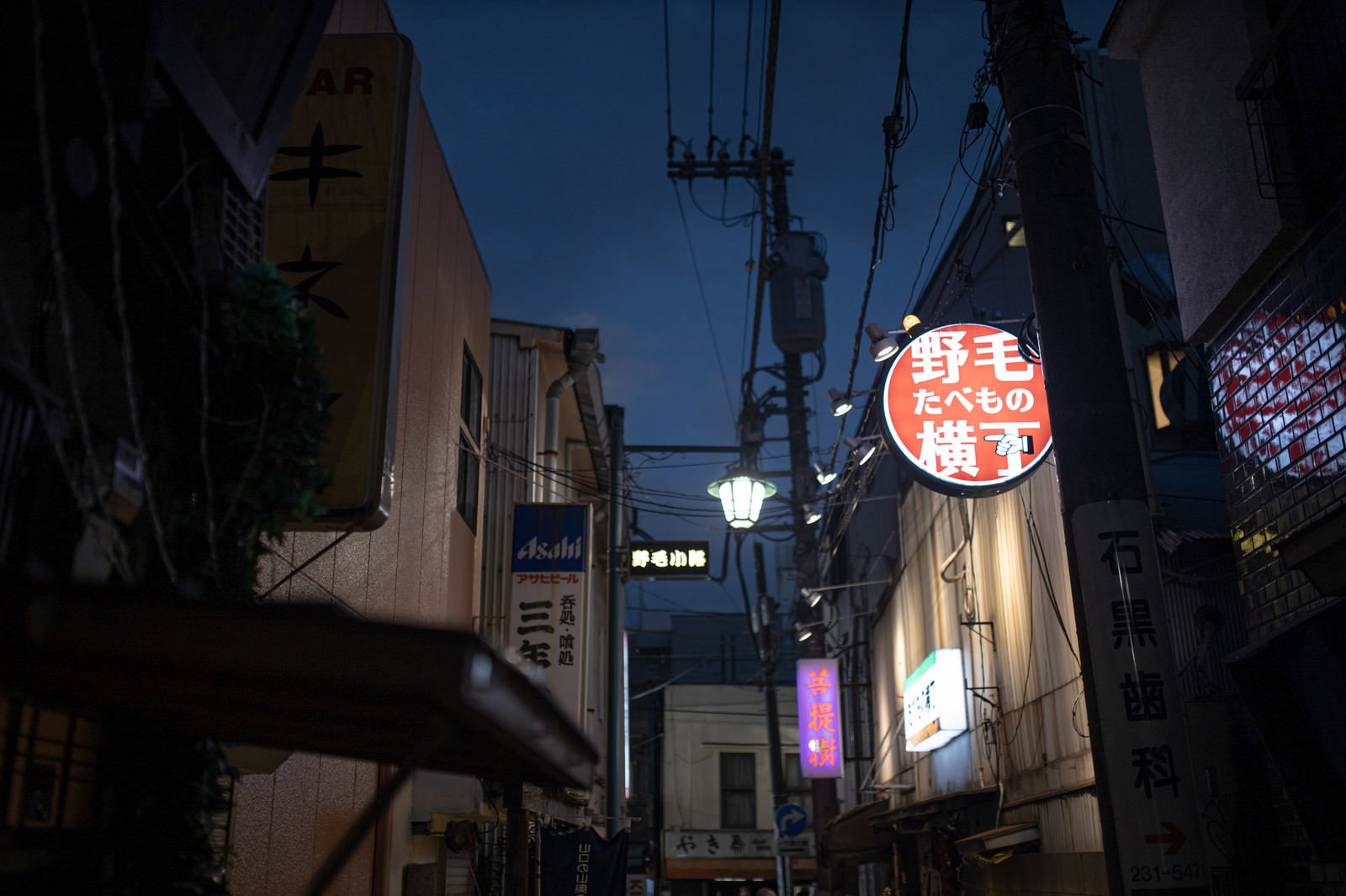 深夜の野毛横丁の路地裏、飲食店の看板が並ぶ夜の風景