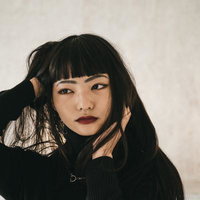 黒い前髪と赤い唇のオンザ眉毛メイク、ぱっつん前髪のポートレートの写真