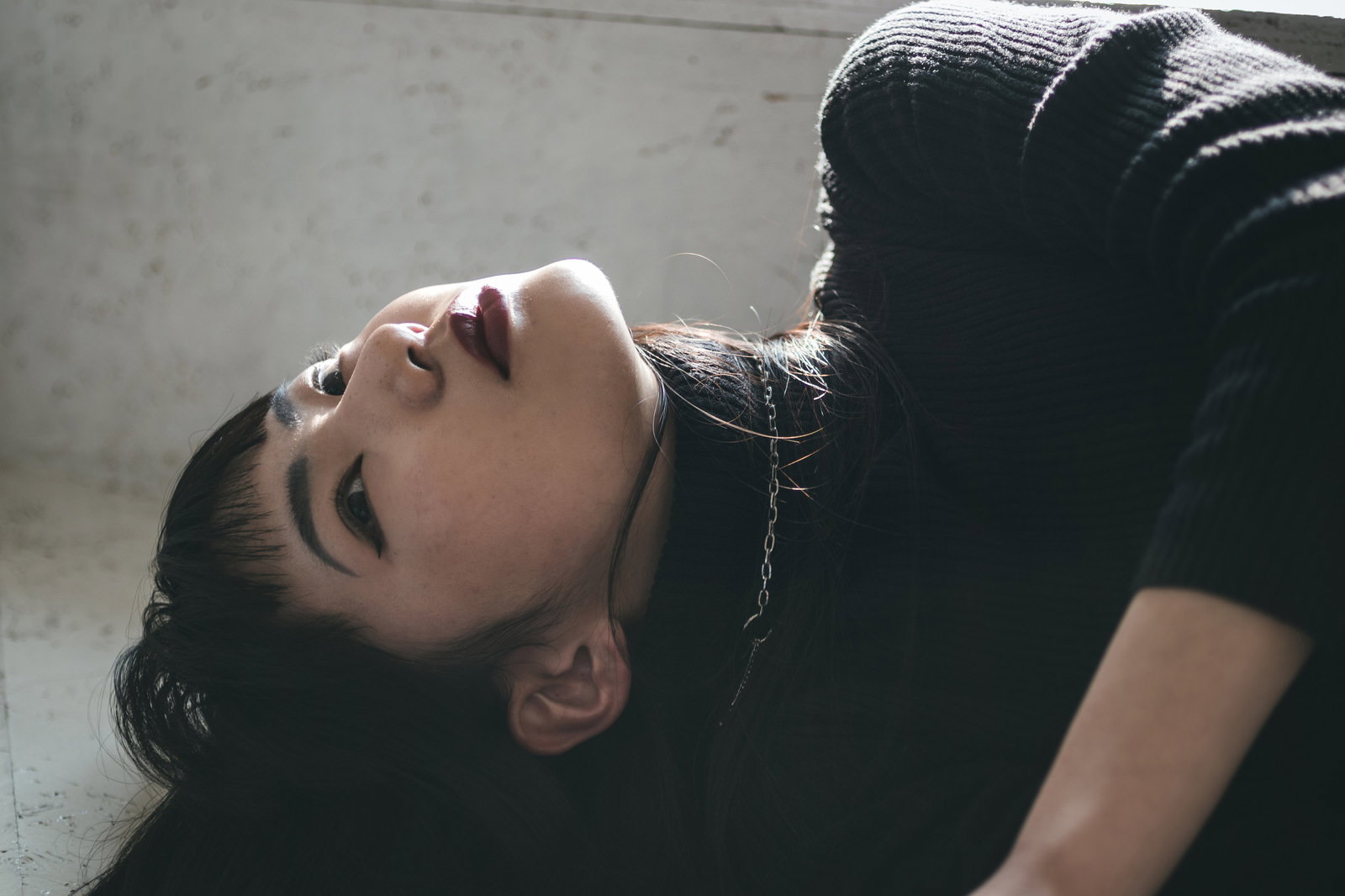 床に横たわり上を向く女性モデル［モデル：なんこ］