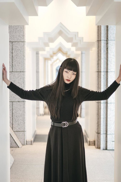 ここを通りたければ私を倒すことね。黒いニットと赤い唇で決める女性