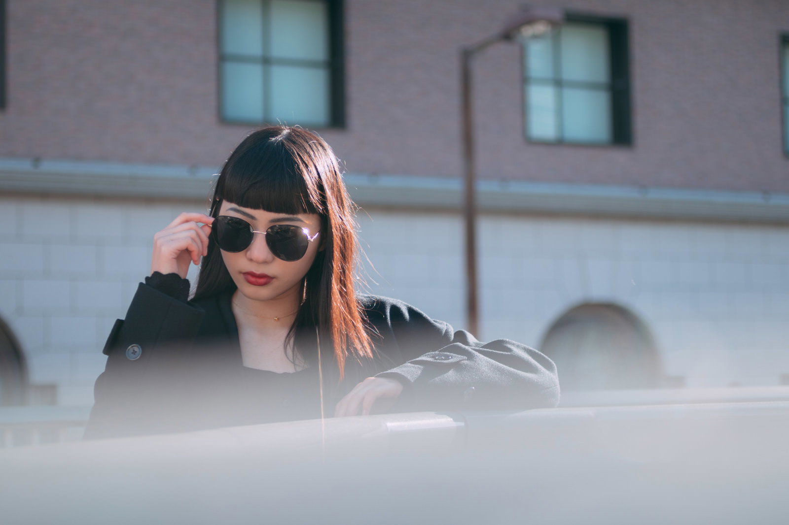 サングラスをかけ、黒いジャケット姿でエージェント風に変装した女性［モデル：なんこ］