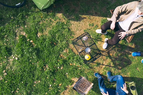 オートキャンプ場でテントやタープを設営するキャンプシーン（空撮）