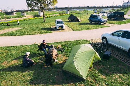 直方オートキャンプ場で和む人たち テント設営とキャンピングカーが並ぶ光景