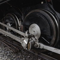 蒸気機関車の大きな動輪と連結棒の機構と軸受け部分の写真