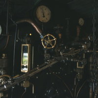 蒸気機関車の機関室内に設置された圧力計とハンドルの写真