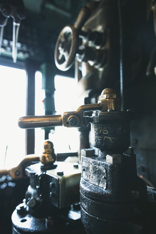 機関室に差す光とブレーキ弁ハンドル、配管とゲージ